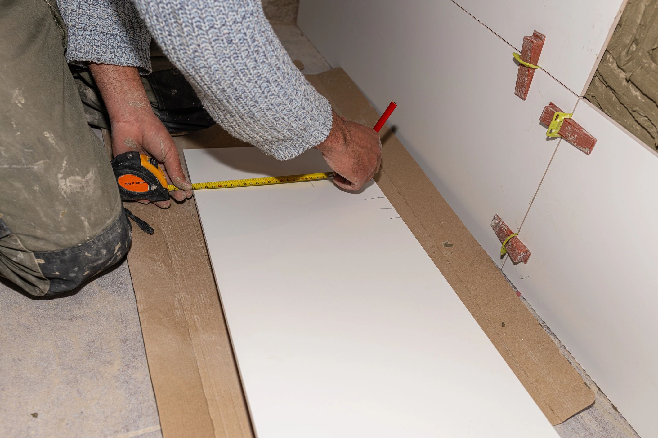 Worker measuring wooden trim molding